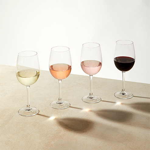 4 different glasses of wine varietals against a beige background