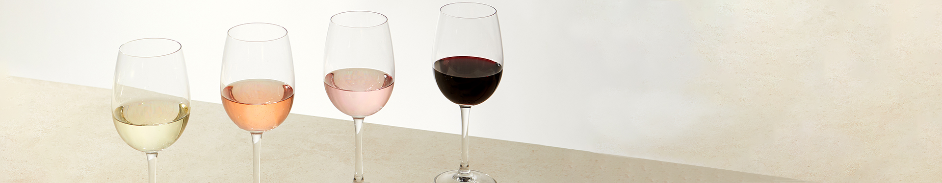 Four glasses of various Tempus Two varietals over a neutral background
