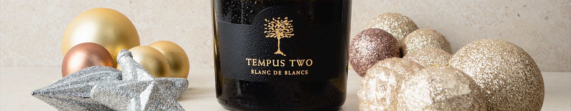 Bottle of Tempus Two Blanc De Blancs with various Christmas decorations
